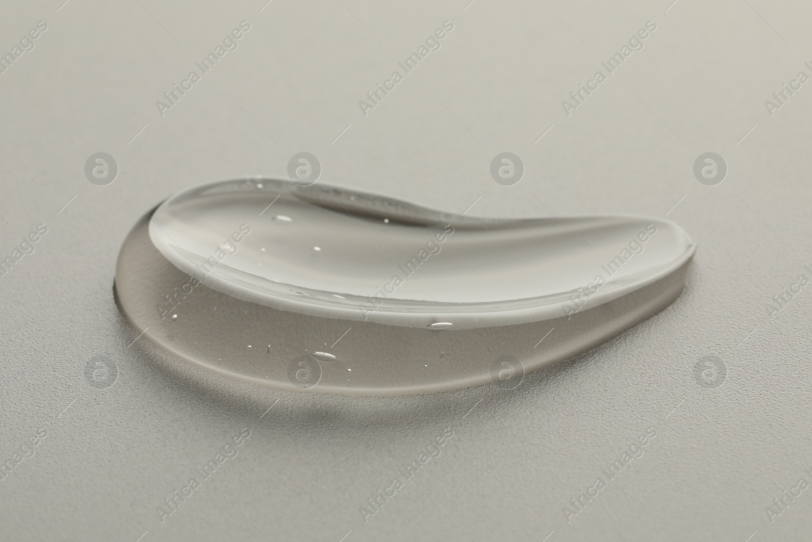 Photo of Sample of clear cosmetic gel on light grey background, closeup
