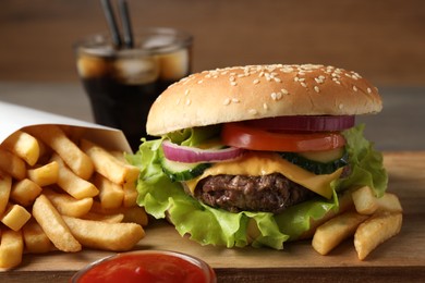 Delicious burger, soda drink and french fries served on wooden table, closeup