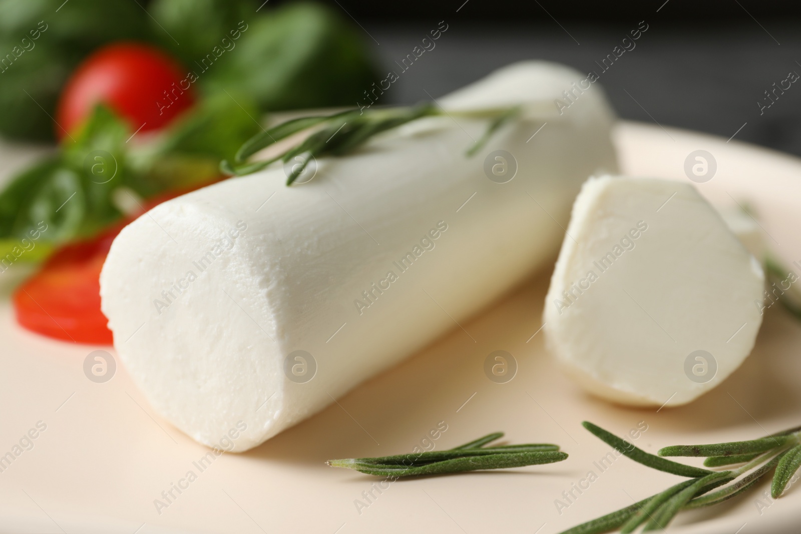 Photo of Delicious goat cheese with rosemary on plate, closeup