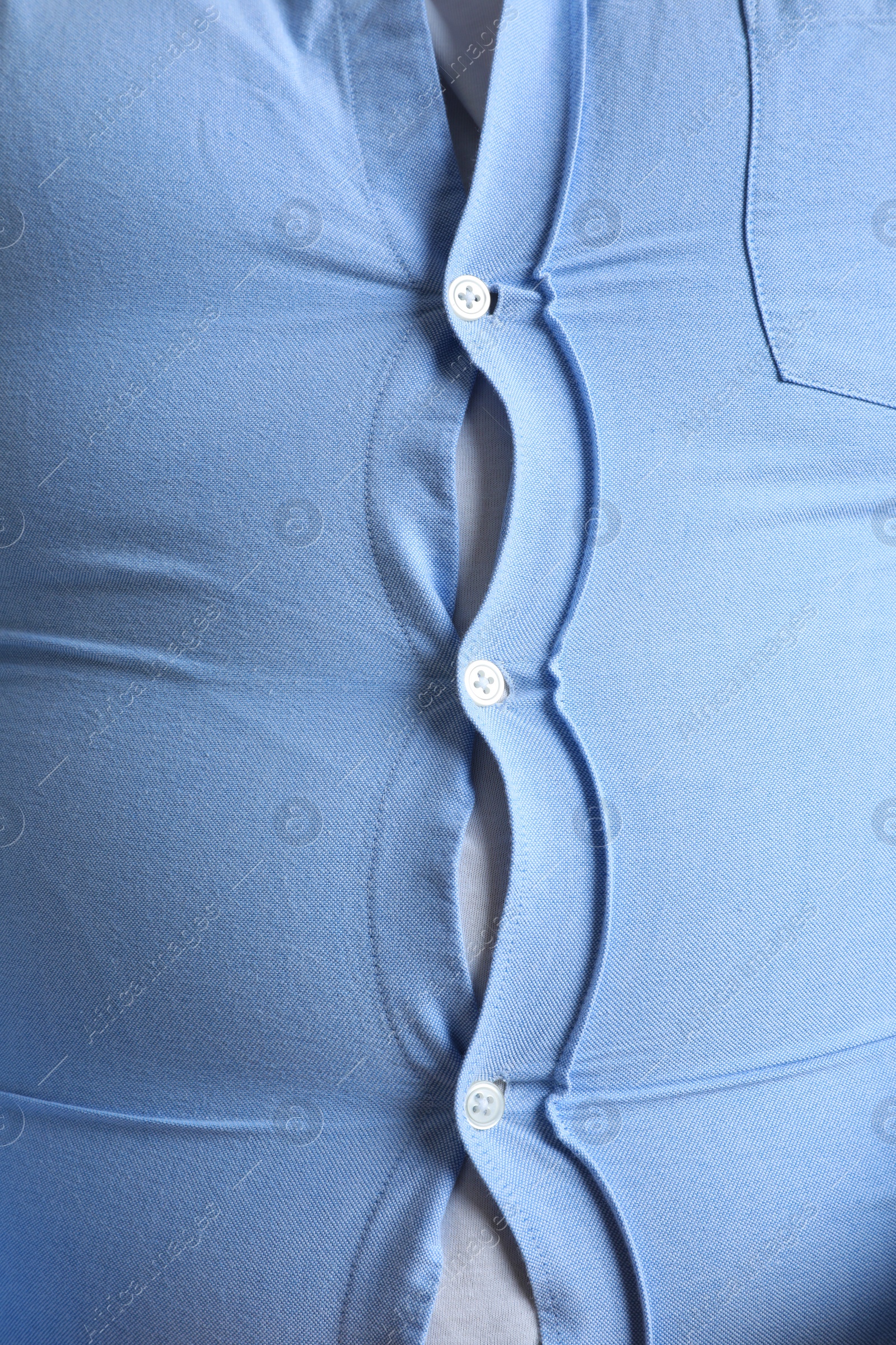 Photo of Closeup view of overweight man in tight shirt as background