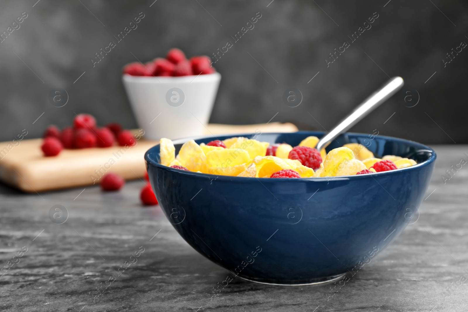 Photo of Bowl with cornflakes and milk on dark table. Whole grain cereal for breakfast