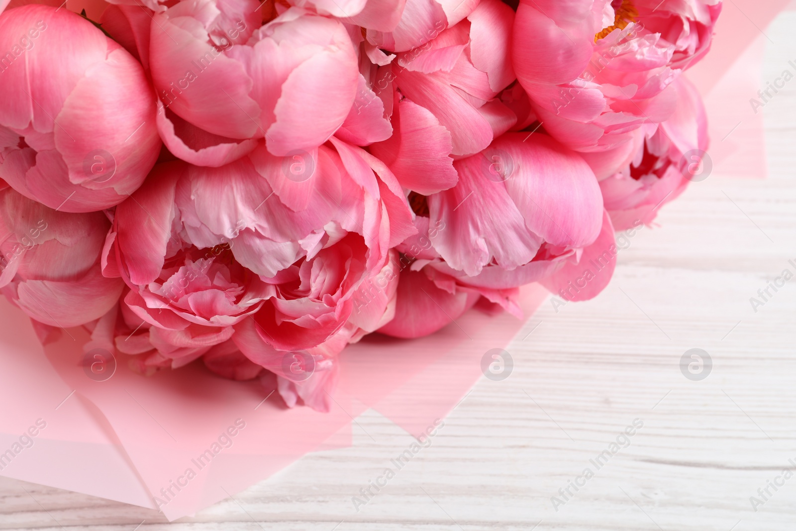 Photo of Bouquet of beautiful pink peonies on white wooden table, closeup