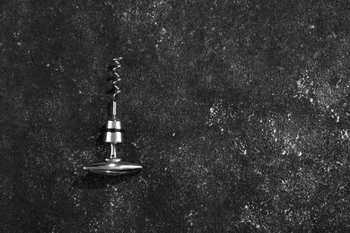 One corkscrew on grey textured table, top view. Space for text