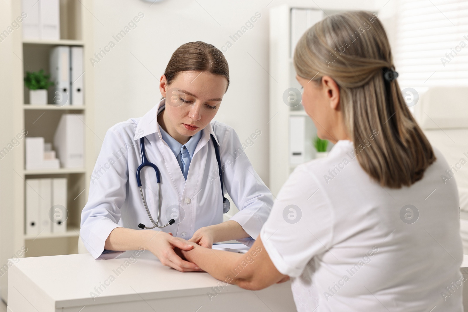 Photo of Arthritis symptoms. Doctor examining patient's wrist in hospital