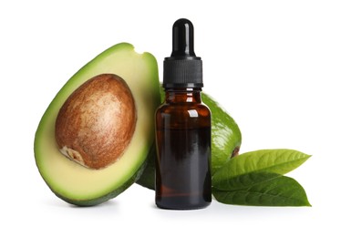 Bottle of essential oil, avocados and leaves on white background