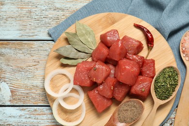 Photo of Raw beef meat and different ingredients for cooking delicious goulash on wooden table, flat lay