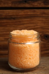 Photo of Jar with orange sea salt on wooden table