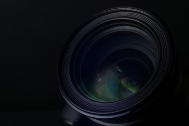 Photo of Lens of professional camera on black background, closeup