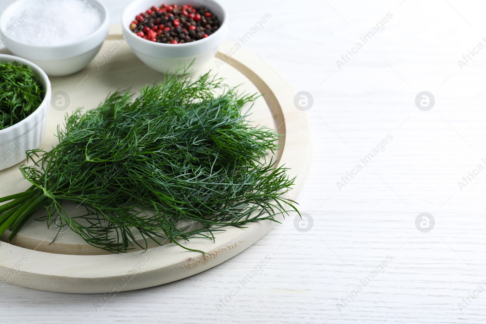 Photo of Bunch of fresh dill on white wooden table, space for text