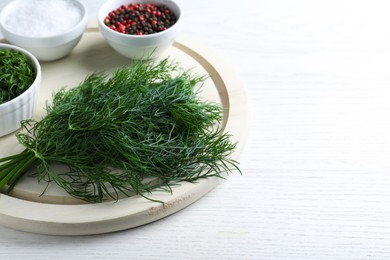 Photo of Bunch of fresh dill on white wooden table, space for text