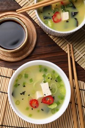 Photo of Bowls of delicious miso soup with tofu served on table, flat lay
