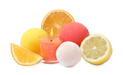 Photo of Citrus bath bombs, burning candle and fresh fruits on white background