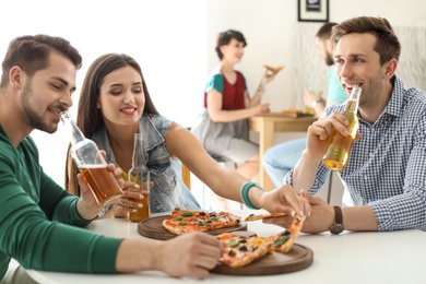 Photo of Young people having fun party with delicious pizza indoors