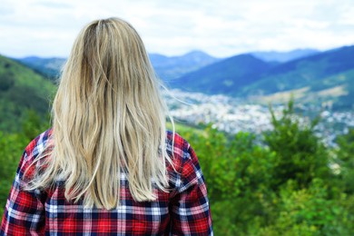 Photo of Woman enjoying beautiful mountain landscape, back view