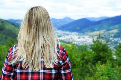 Woman enjoying beautiful mountain landscape, back view