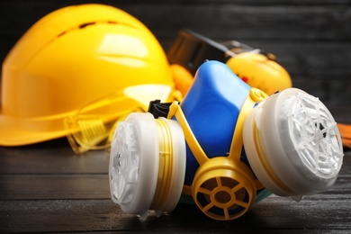 Photo of Gas mask and blurred safety equipment on background