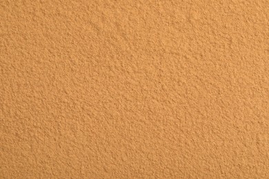 Dry aromatic cinnamon powder as background, top view