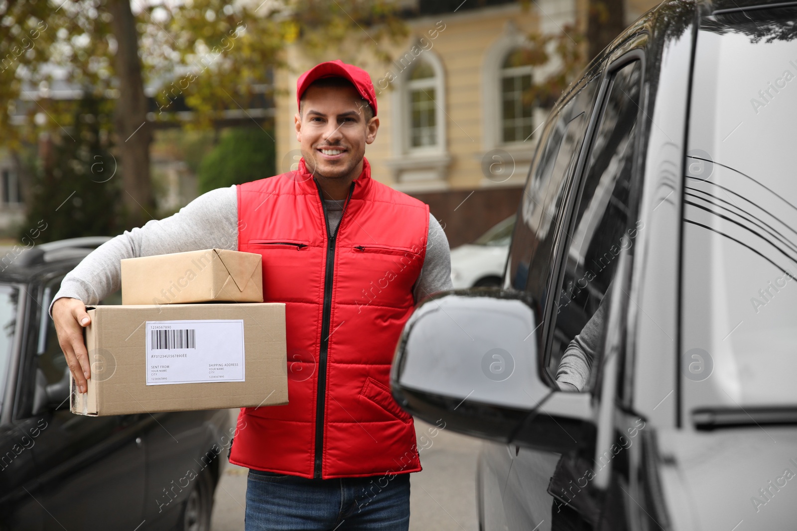 Photo of Courier with parcels near delivery van outdoors