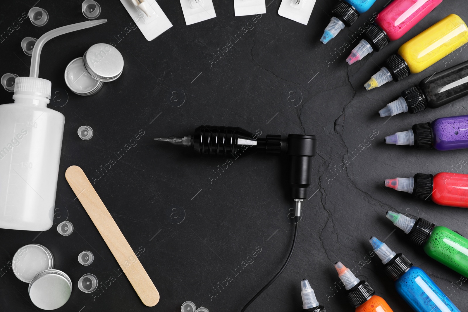 Photo of Flat lay composition with tattoo equipment on black table