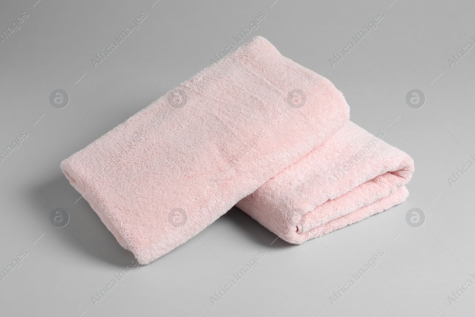 Photo of Fresh soft folded towels on light background