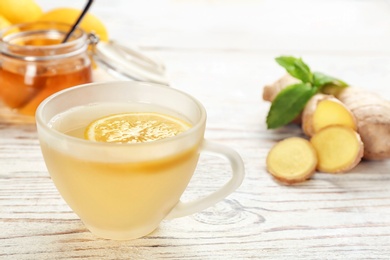 Cup with hot tea and lemon for cold on wooden table