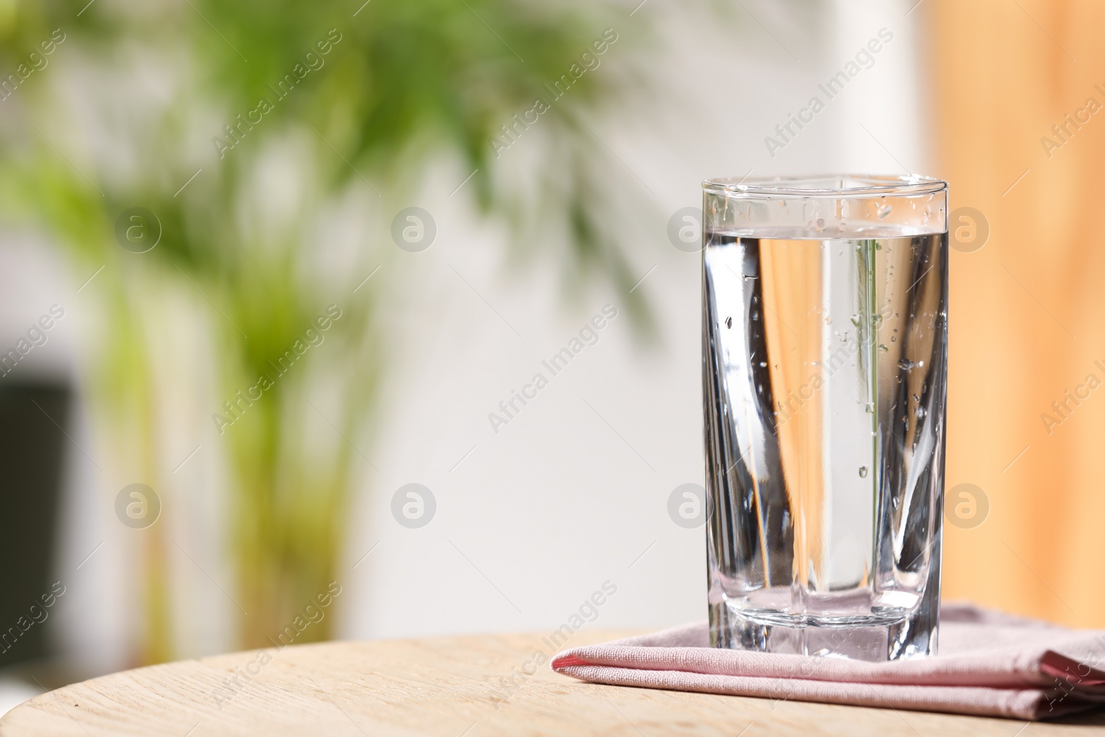 Photo of Glass of pure water on wooden table indoors, space for text