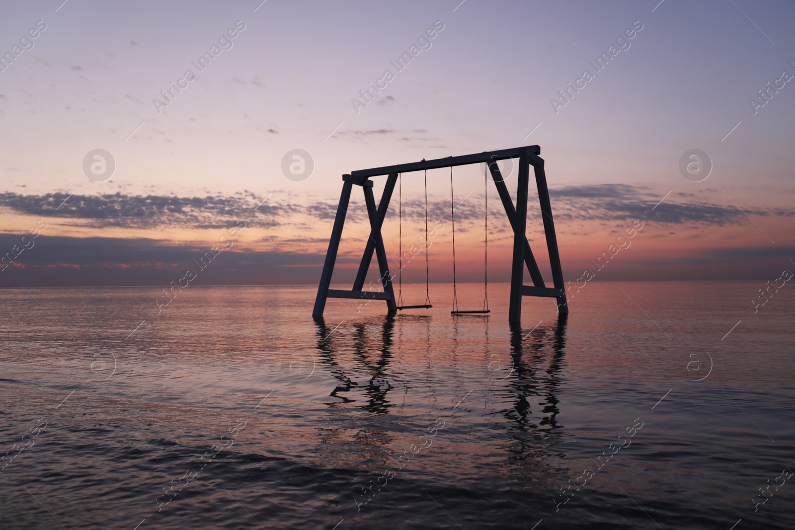 Photo of Picturesque view of swing in water on sunrise