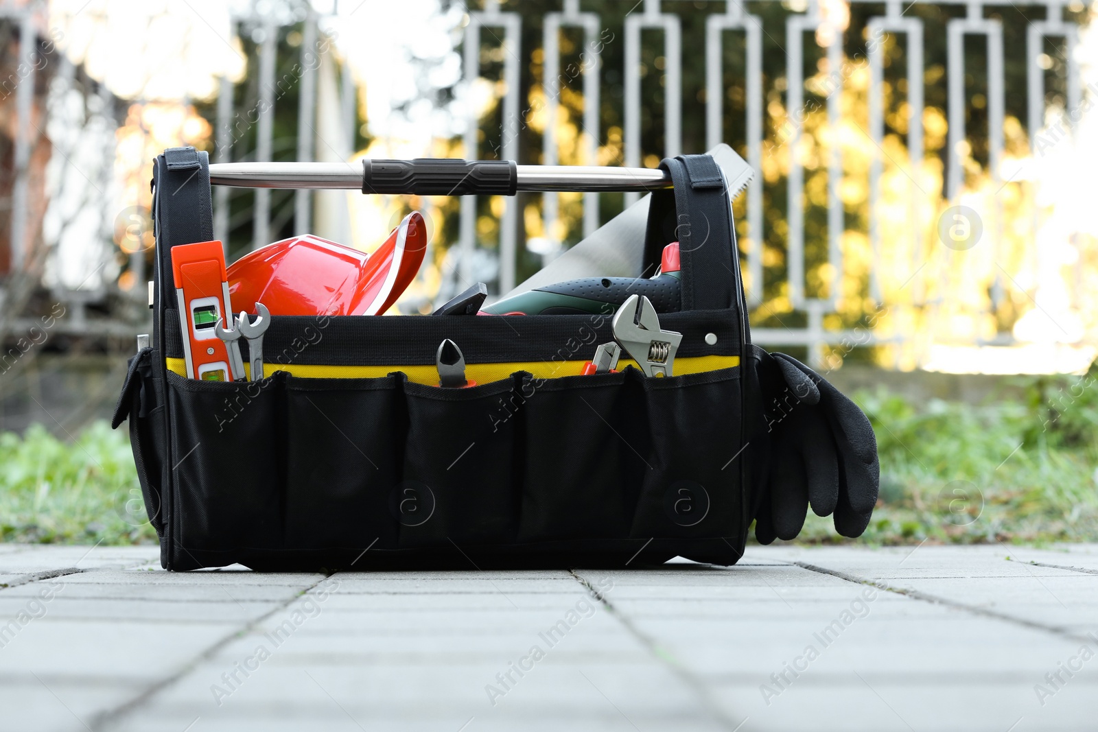 Photo of Bag with different tools for repair on street tiles outdoors