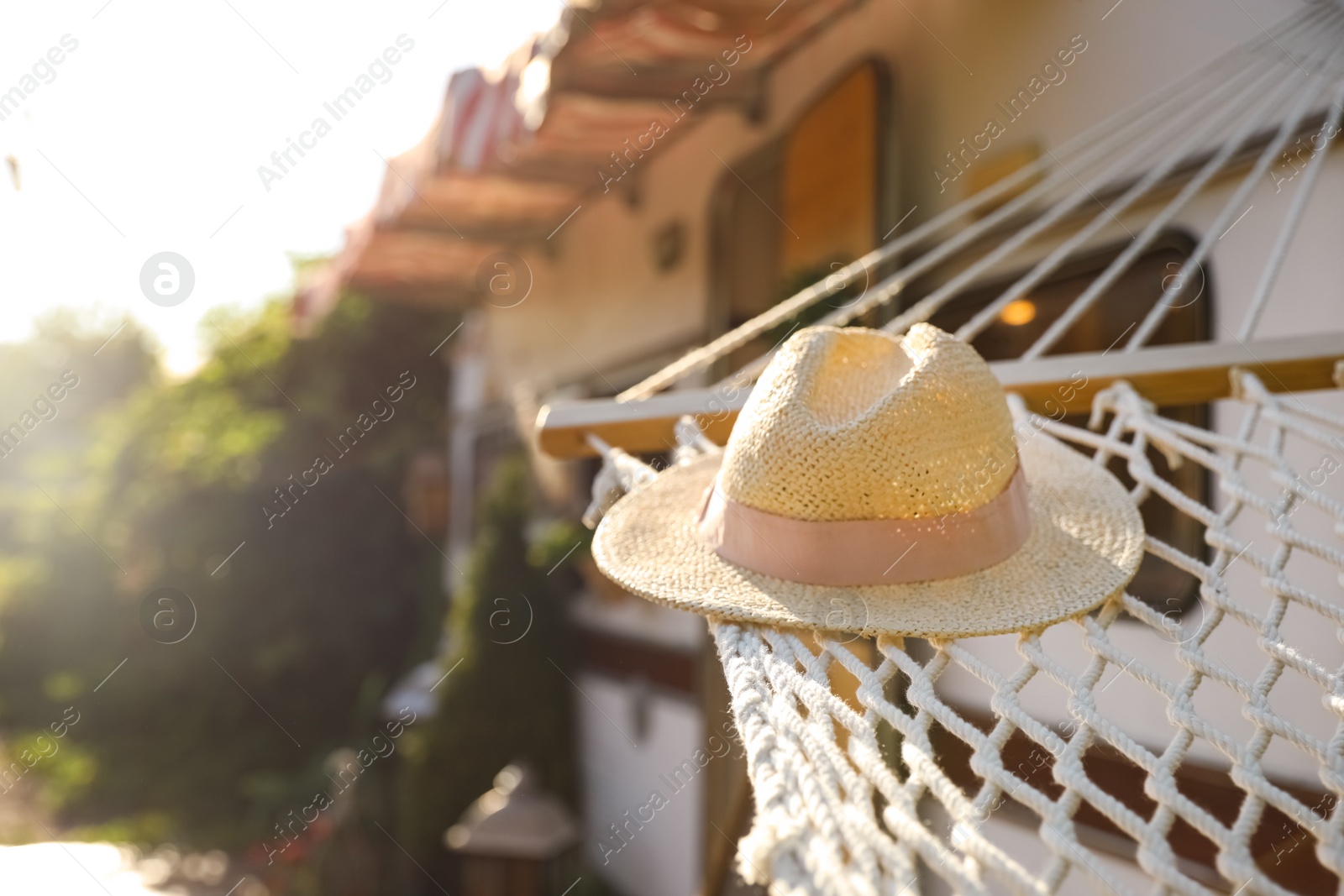 Photo of Comfortable hammock with hat near motorhome outdoors on sunny day