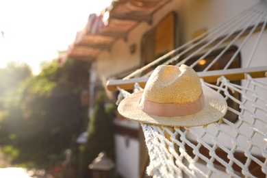 Comfortable hammock with hat near motorhome outdoors on sunny day