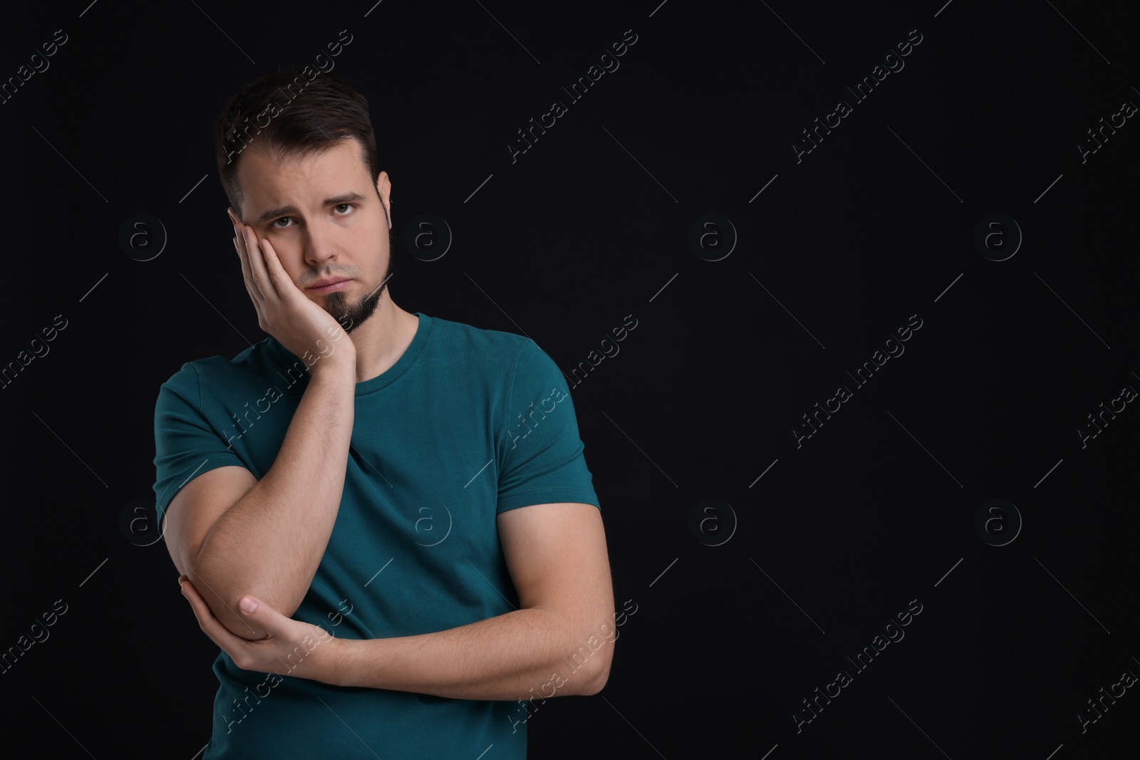 Photo of Portrait of sad man on black background, space for text