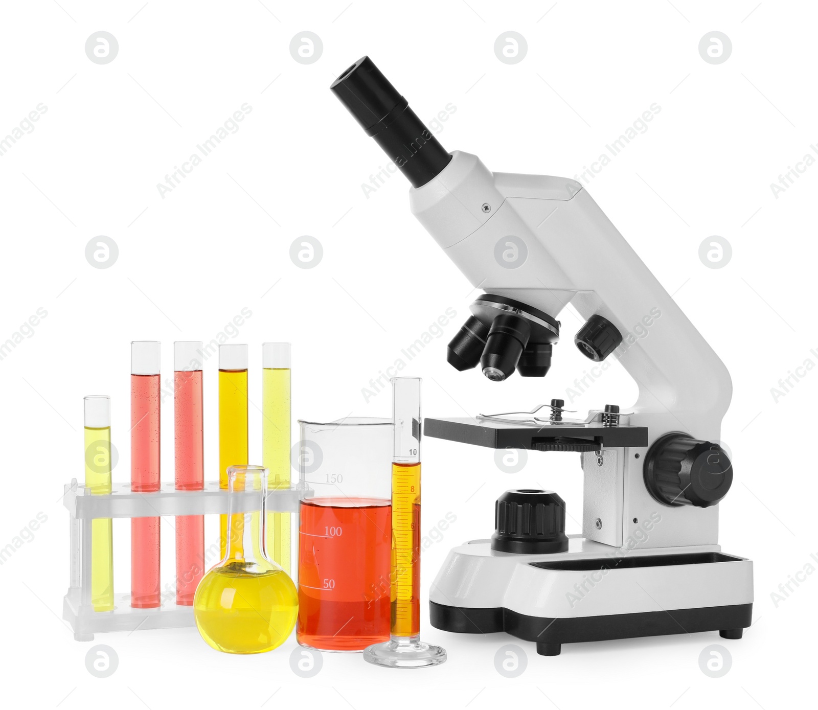 Photo of Laboratory glassware with colorful liquids and microscope isolated on white