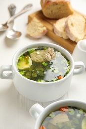 Photo of Delicious sorrel soup with meat and egg served on white wooden table