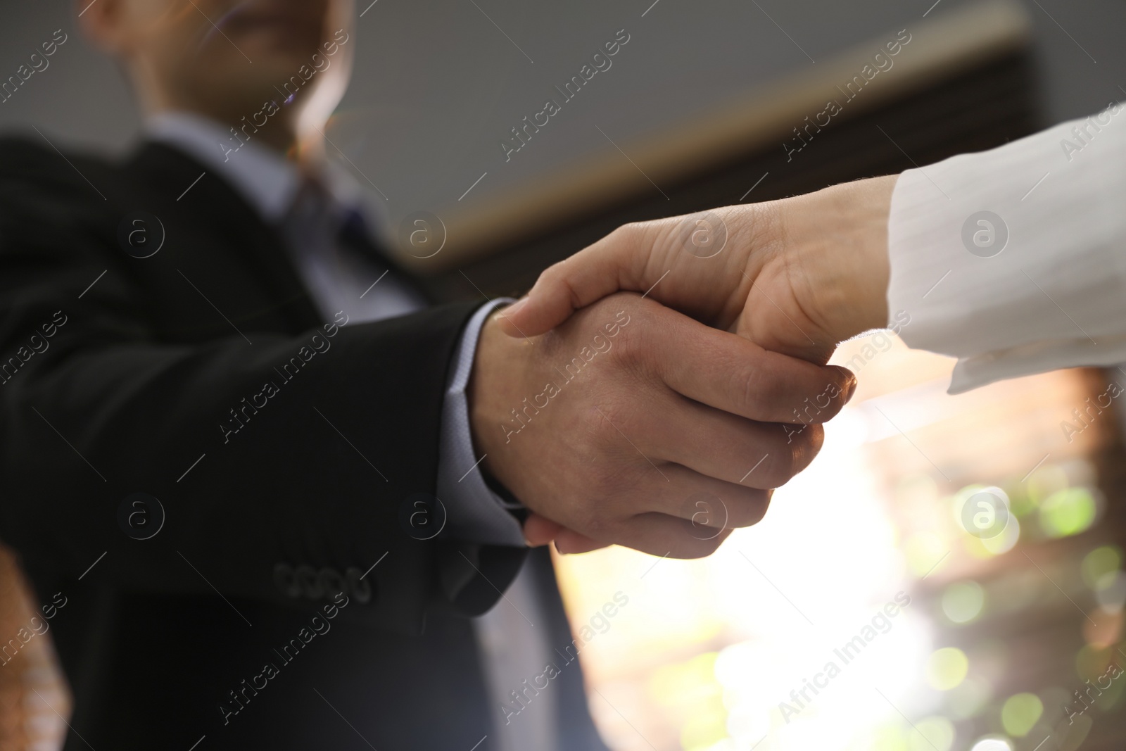 Photo of Business people shaking hands in office, closeup