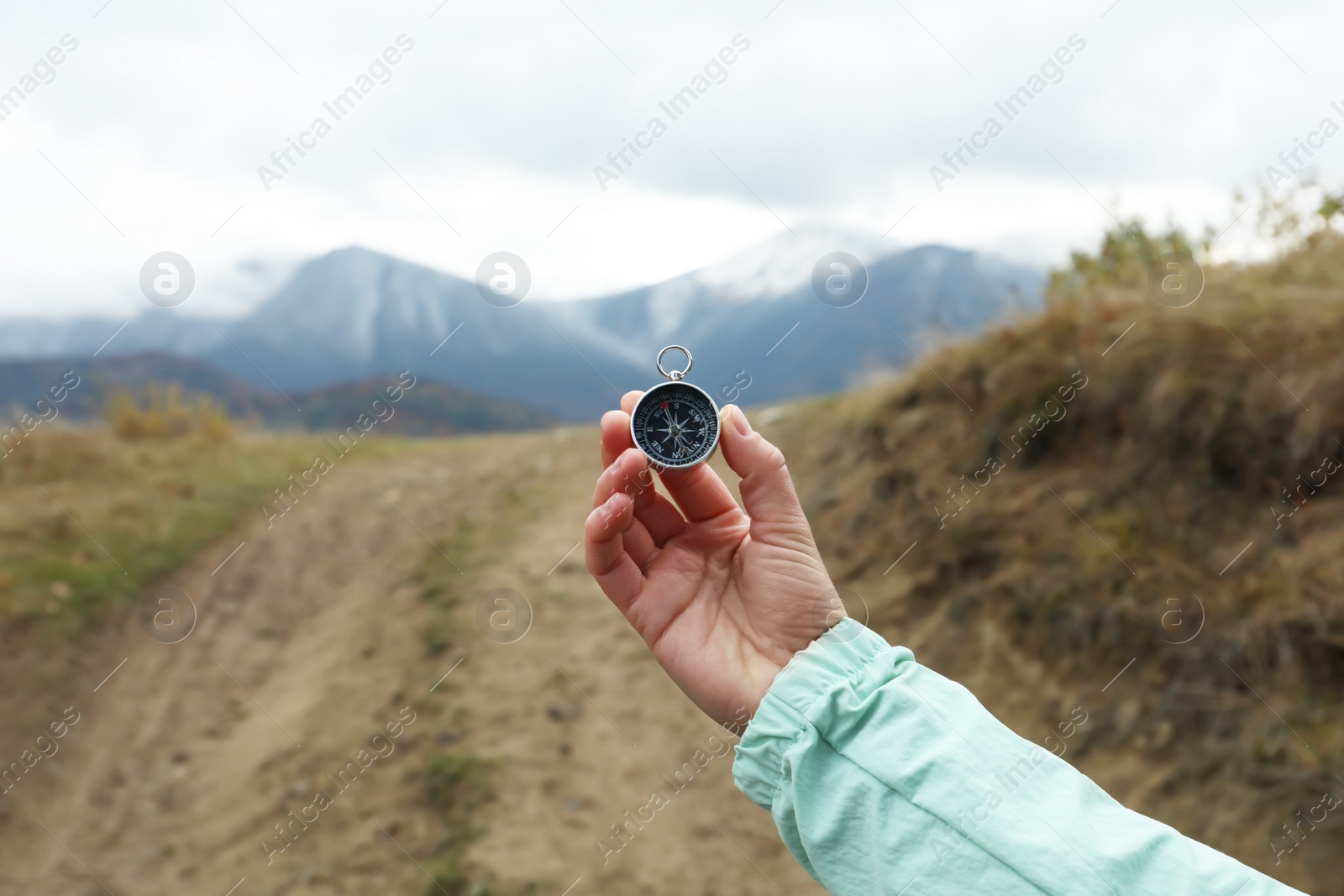 Photo of Woman using compass during journey in mountains, closeup