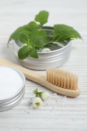 Toothbrush, dental products and herbs on white wooden table, closeup