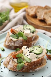 Photo of Tasty vegan sandwiches with tofu, cucumber, tomato and sesame seeds on table, closeup