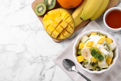 Photo of Delicious fruit salad on white marble table, flat lay. Space for text