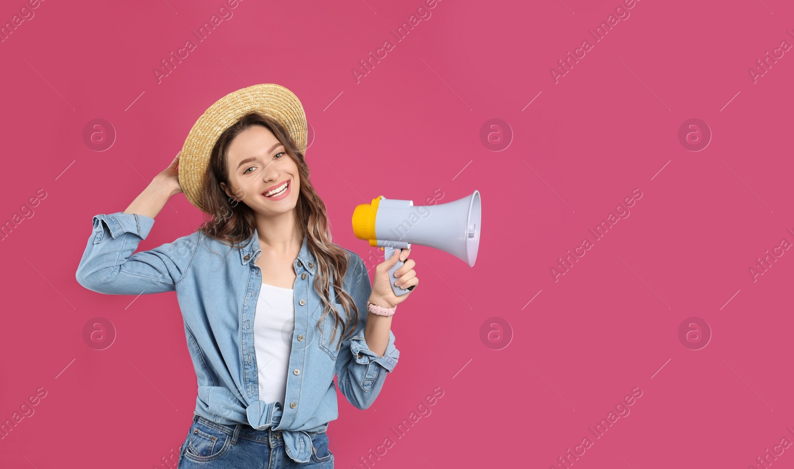 Photo of Young woman with megaphone on pink background