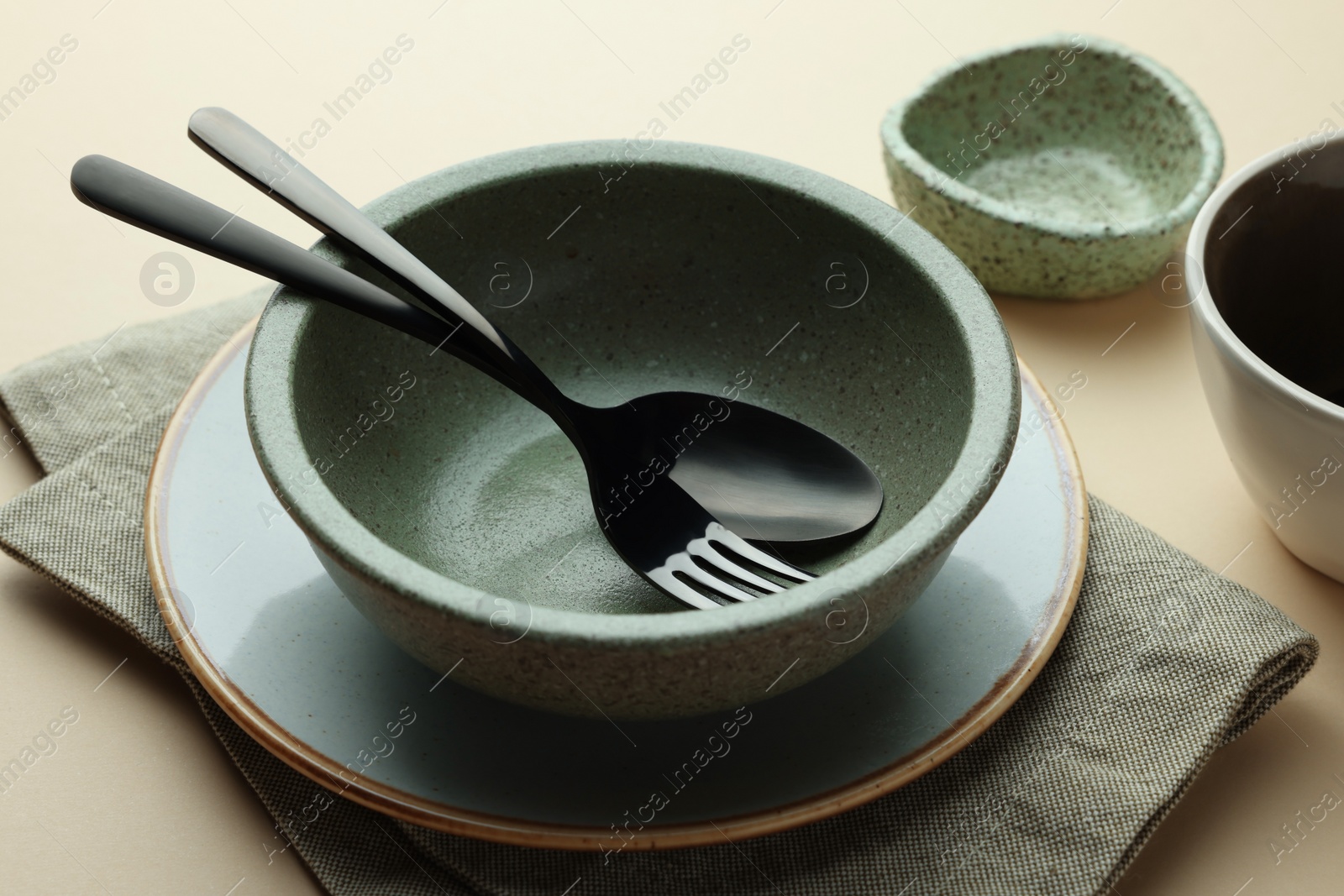 Photo of Stylish empty dishware and cutlery on beige background, closeup