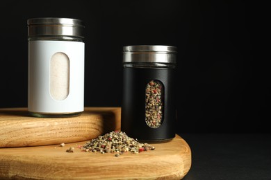 Salt and pepper shakers on table against black background