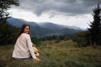 Photo of Young woman enjoying beautiful mountain landscape. Space for text