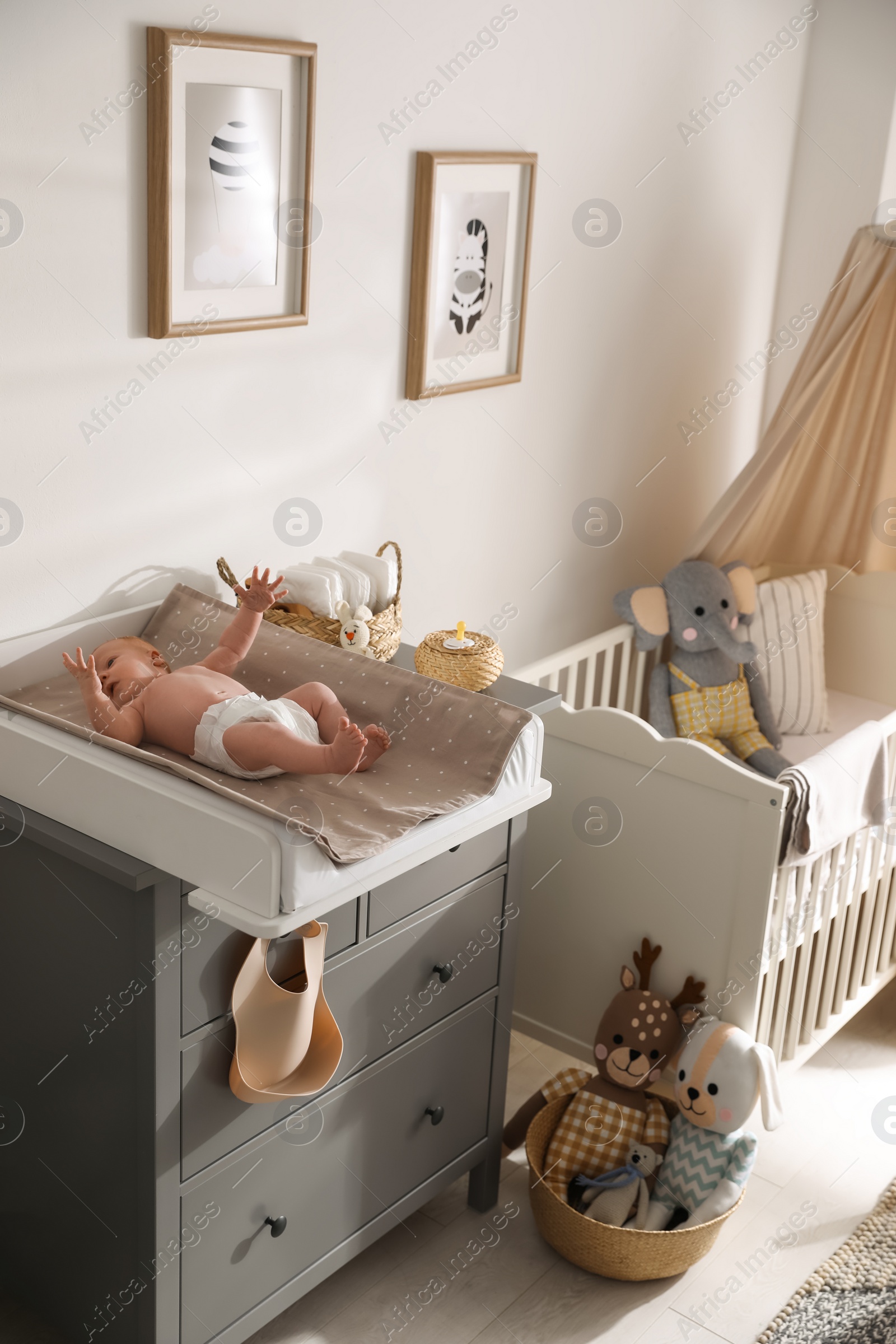 Photo of Cute little baby on changing table in room