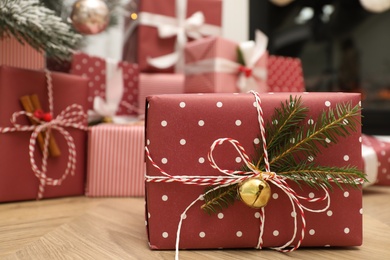 Photo of Beautiful Christmas gift and blurred pile of presents on background. Space for text