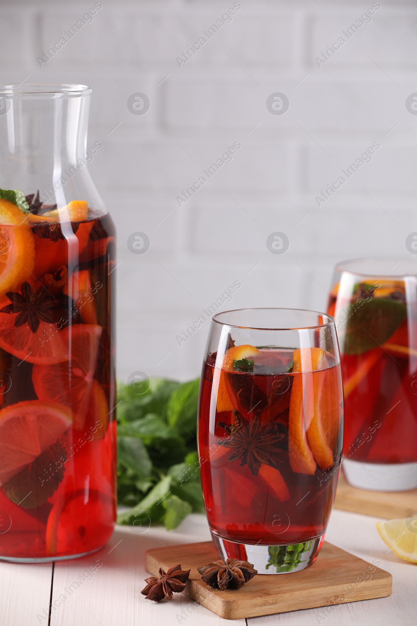 Photo of Delicious punch drink and anise stars on white wooden table