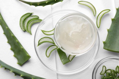Aloe vera gel and slices of plant on white background, flat lay
