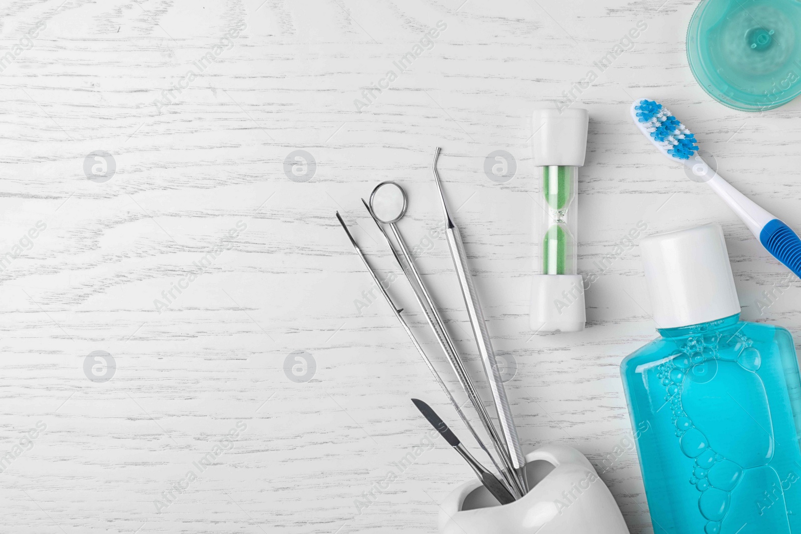 Photo of Flat lay composition with dentist tools and teeth care objects on wooden background. Space for text