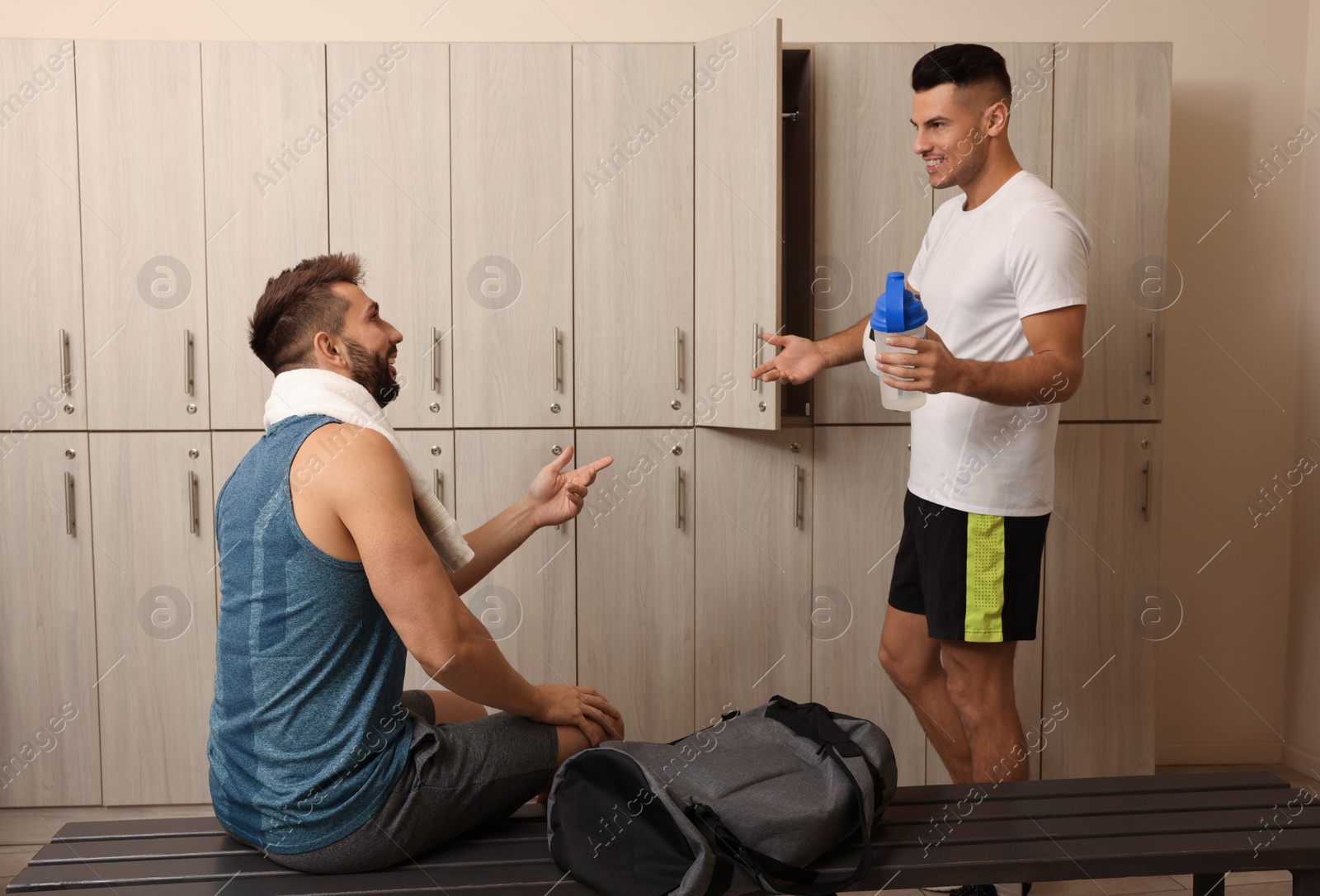 Photo of Handsome athletic men talking in locker room