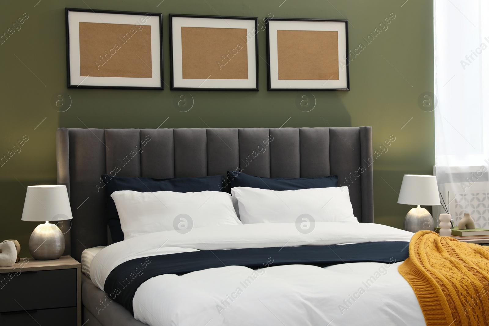 Photo of Large comfortable bed and lamps in stylish room. Interior design