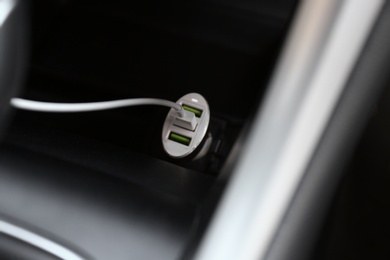 Charging cable connected to plug in car, closeup